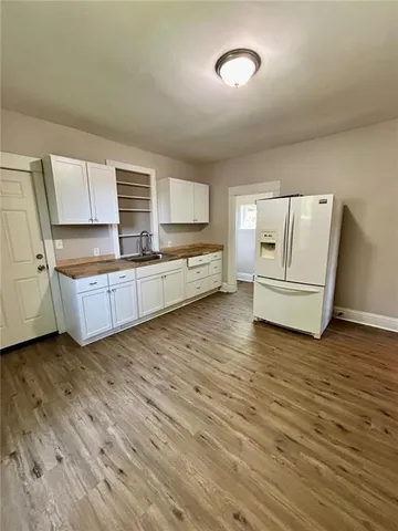 a large kitchen with a wooden floor and white stainless steel appliances