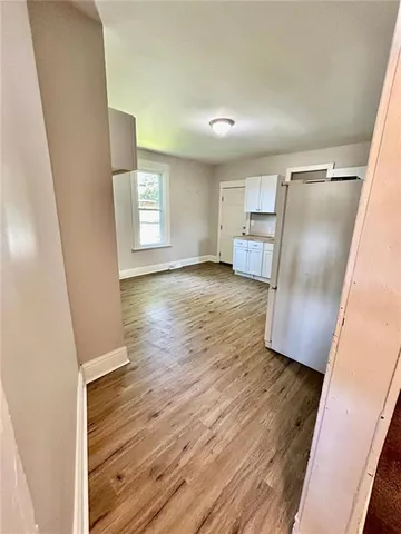 a view of a kitchen with wooden floor and electronic appliances