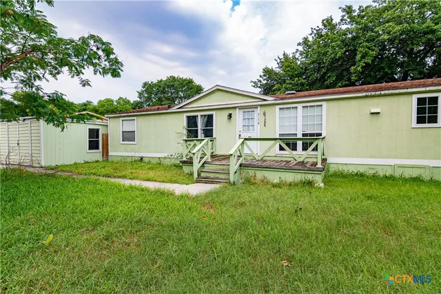 a view of a house with a backyard