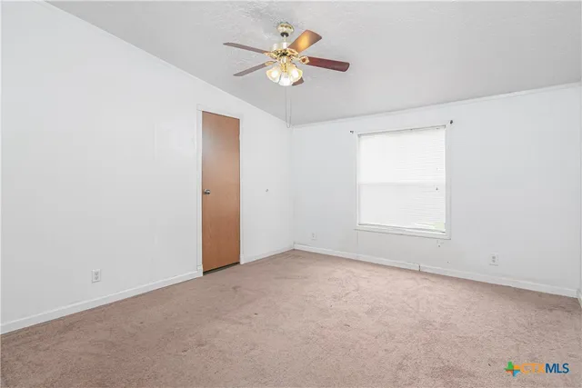 an empty room with closet and a ceiling fan