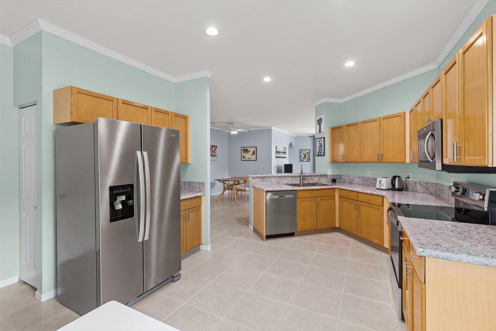 311 Southwest Coconut Key Way Port St. Lucie, FL 34986 - Photo 11 of 25 a large kitchen with stainless steel appliances granite countertop a refrigerator and a sink