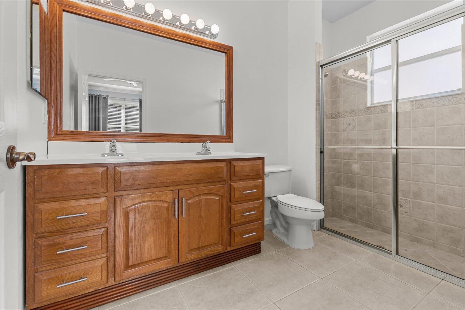 311 Southwest Coconut Key Way Port St. Lucie, FL 34986 - Photo 19 of 25 a bathroom with a toilet a sink and mirror