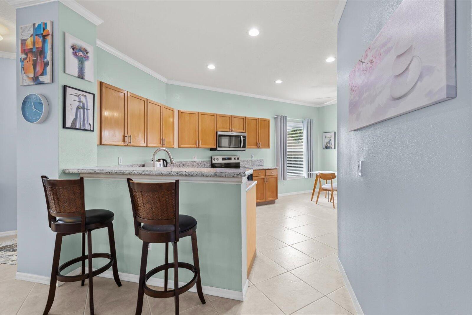 311 Southwest Coconut Key Way Port St. Lucie, FL 34986 - Photo 8 of 25 a kitchen with stainless steel appliances a microwave a stove a sink dishwasher and cabinets with wooden floor