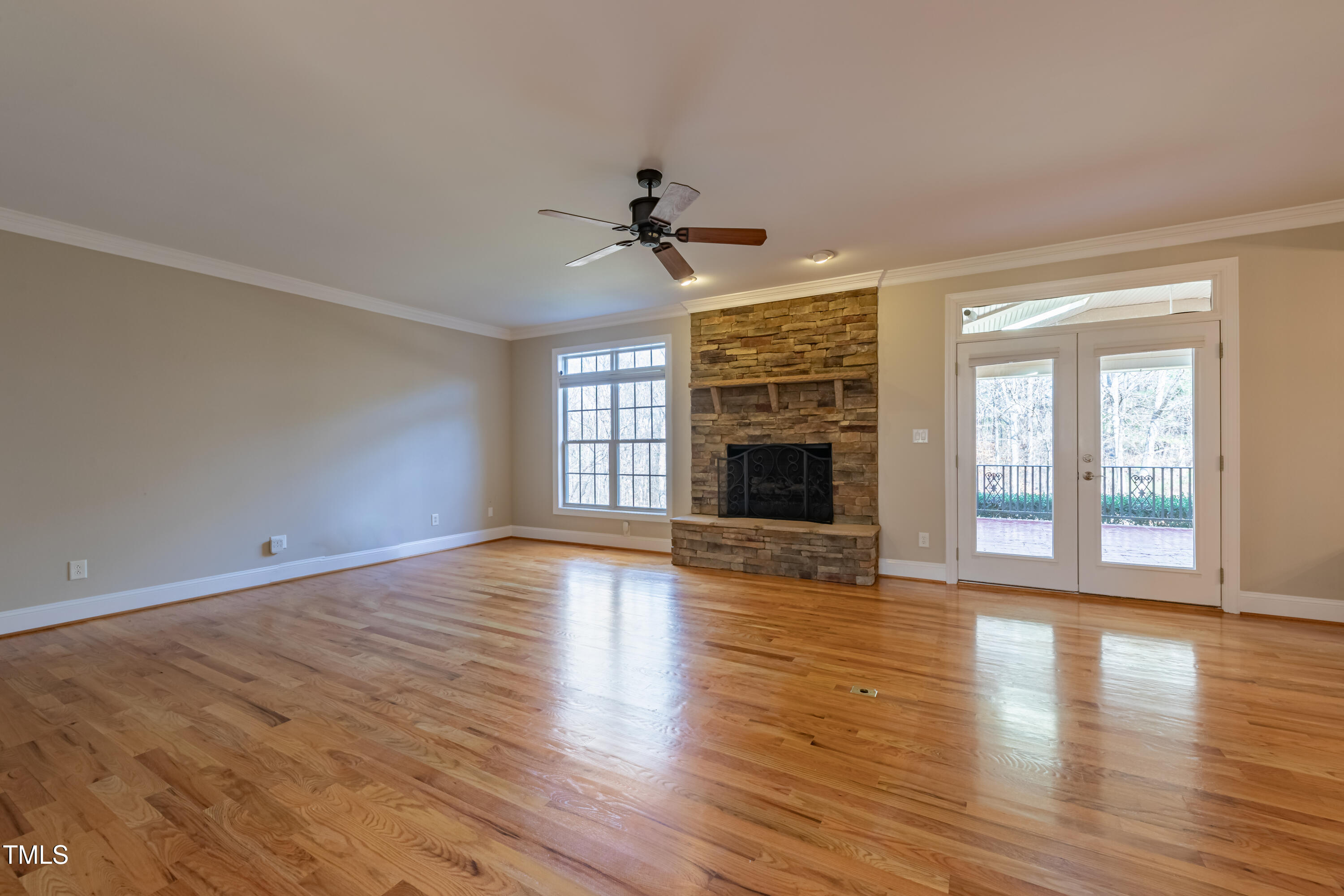 1408 Goldengate Court Raleigh, NC 27613 - Photo 11 of 64 an empty room with wooden floor fireplace and windows