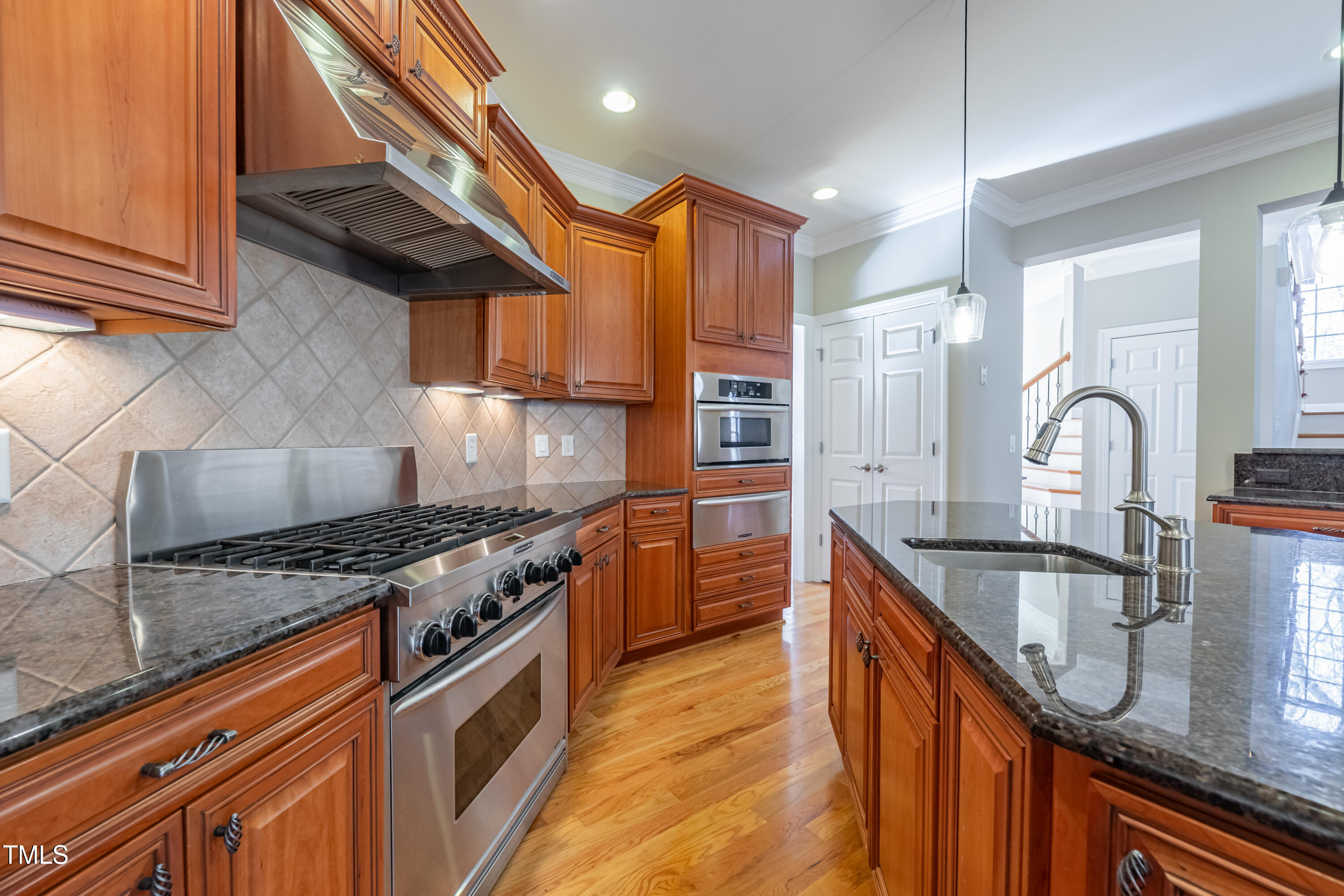 1408 Goldengate Court Raleigh, NC 27613 - Photo 19 of 64 a kitchen with granite countertop a sink a stove and cabinets