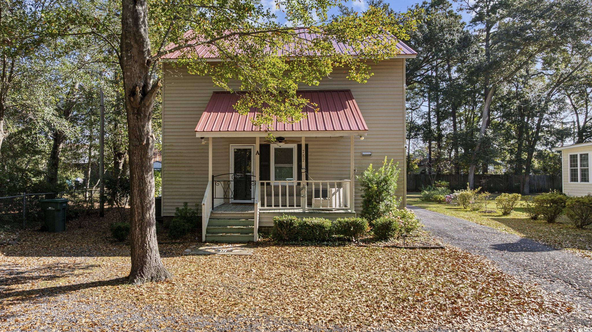 View of front of property with a metal roof, covered porch, and ceiling fan