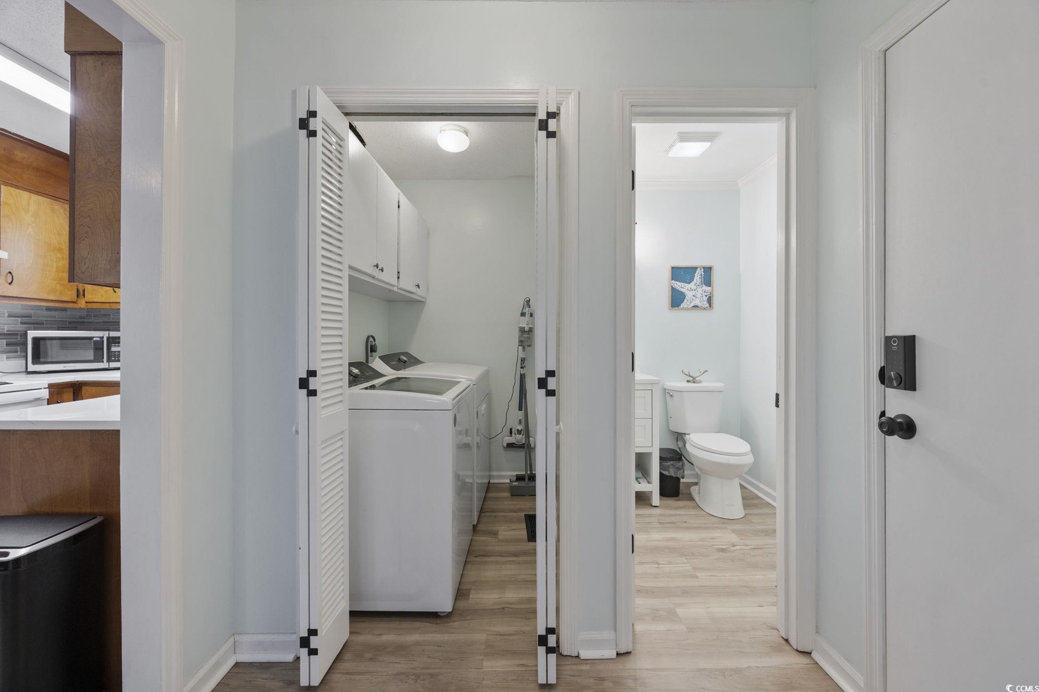787 Causey Road Murrells Inlet, SC 29576 - Photo 30 of 40 Laundry room with cabinet space, light wood-style floors, washer and clothes dryer, and ornamental molding