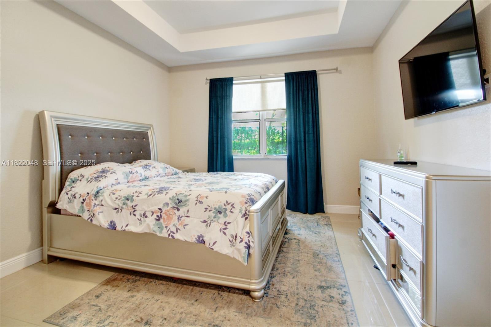 2131 Northeast 37th Road Homestead, FL 33033 - Photo 14 of 34 a bedroom with a bed and a flat tv screen on dresser