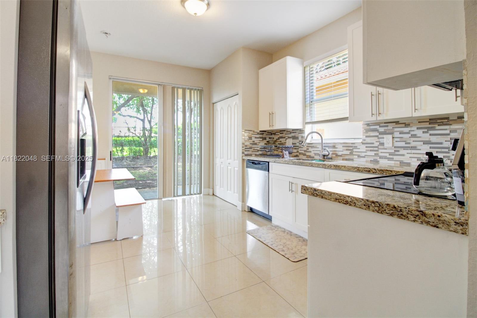 2131 Northeast 37th Road Homestead, FL 33033 - Photo 16 of 34 a large white kitchen with a sink and a large window