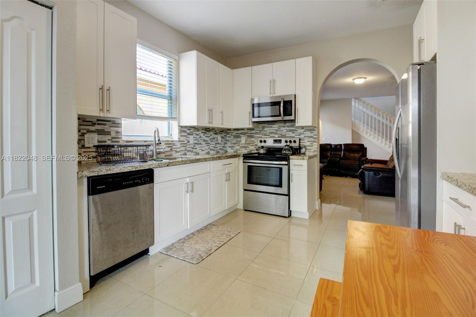 2131 Northeast 37th Road Homestead, FL 33033 - Photo 18 of 34 a kitchen with stainless steel appliances kitchen island granite countertop a stove sink and cabinets
