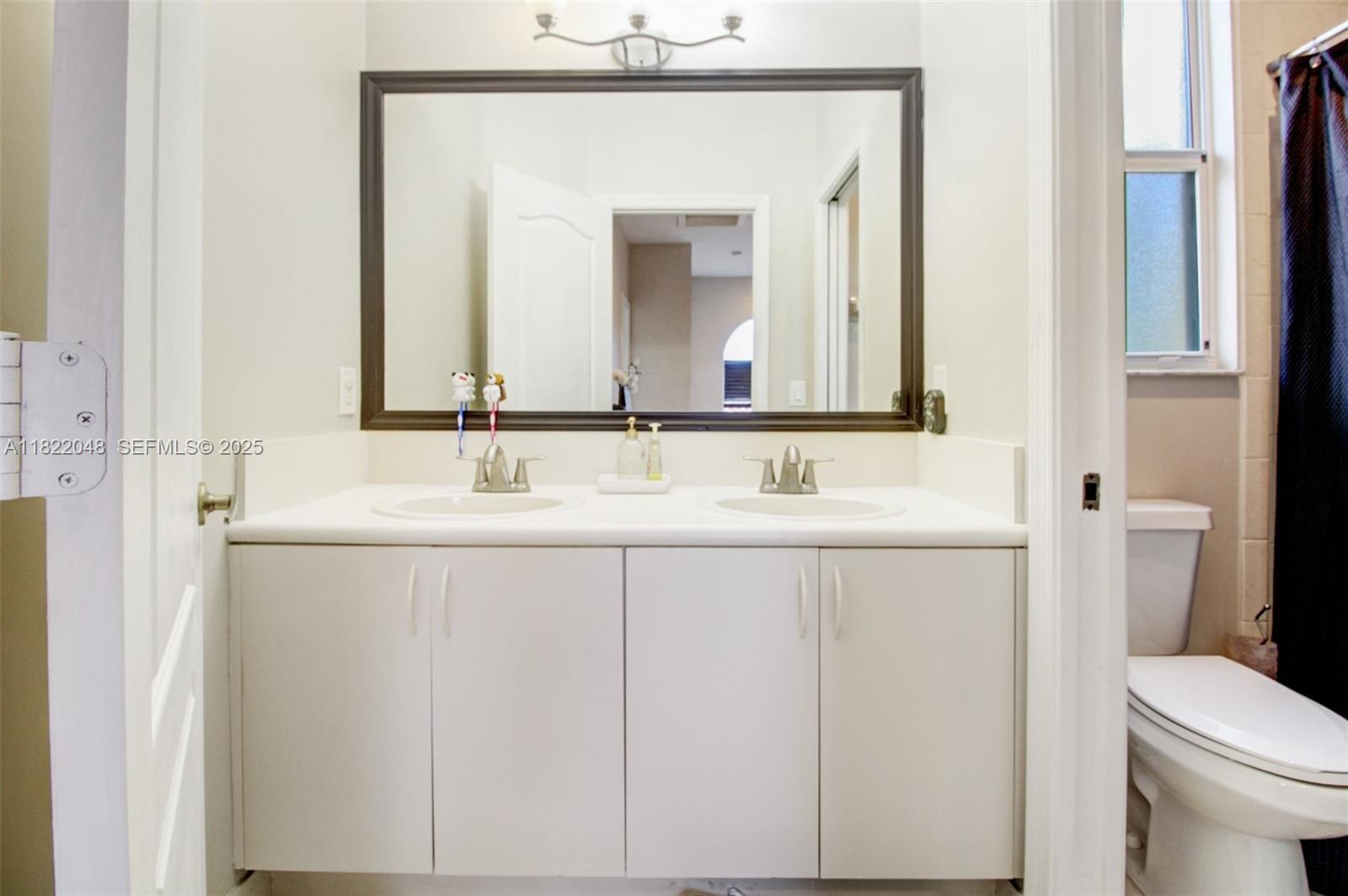 2131 Northeast 37th Road Homestead, FL 33033 - Photo 21 of 34 a bathroom with a sink a toilet and a mirror