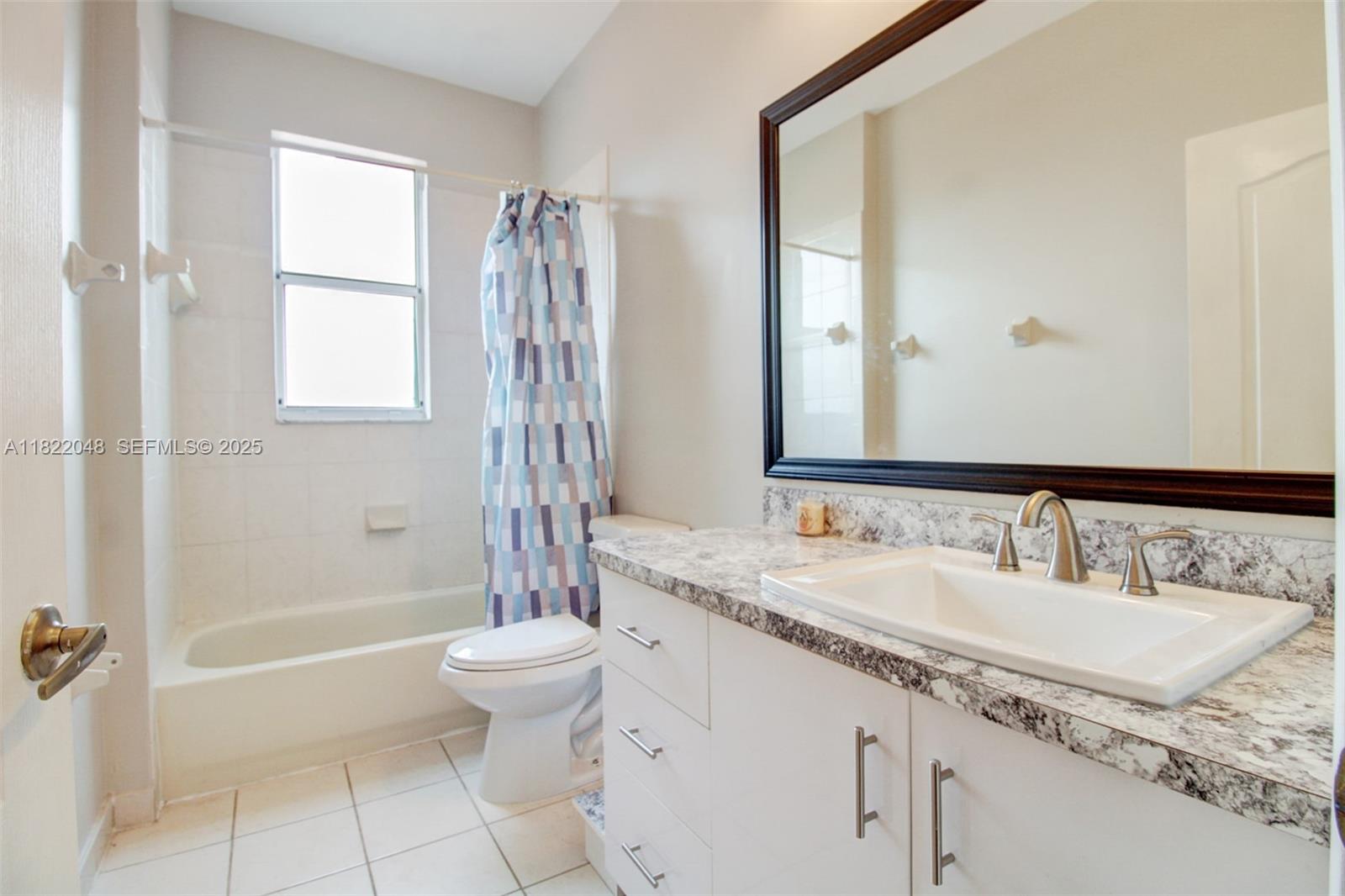 2131 Northeast 37th Road Homestead, FL 33033 - Photo 28 of 34 a bathroom with a granite countertop sink a toilet a mirror and bathtub