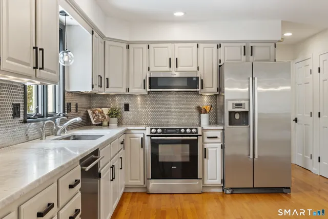 a view of a roof deck with table and chairs under an umbrella with wooden floor