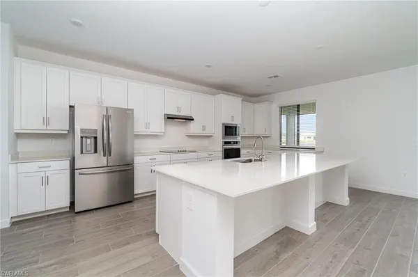 a kitchen with stainless steel appliances a refrigerator sink and stove