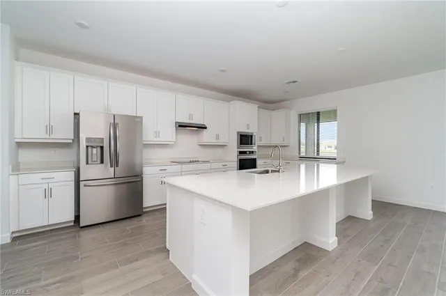 a kitchen with stainless steel appliances a refrigerator sink and stove