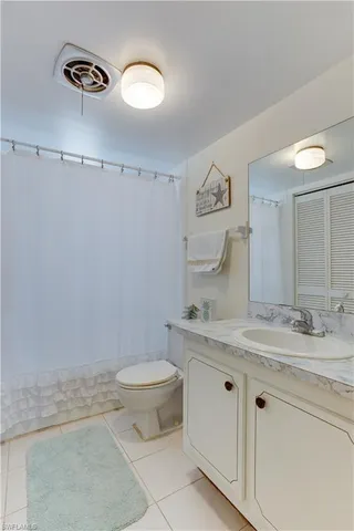 a bathroom with a granite countertop sink a toilet and a mirror