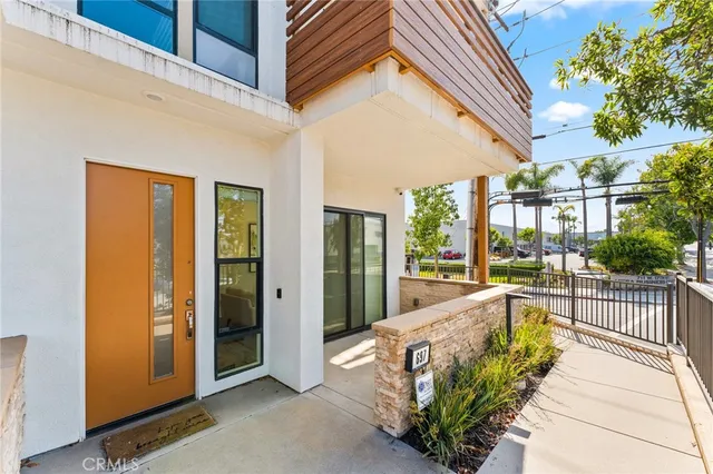 a view of a patio with table and chairs and floor to ceiling window and potted plants