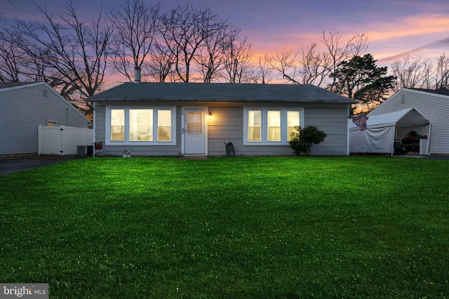 a view of a house with a big yard and large tree