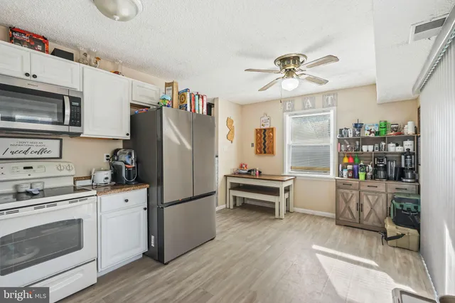 a kitchen with stainless steel appliances a stove a refrigerator and cabinets