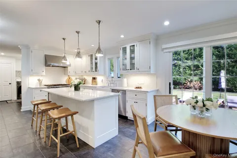 a kitchen with kitchen island granite countertop a table chairs sink and cabinets
