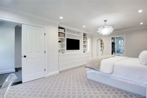 a spacious bedroom with a bed and a flat screen tv