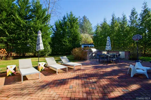 a view of a patio with table and chairs potted plants and large tree