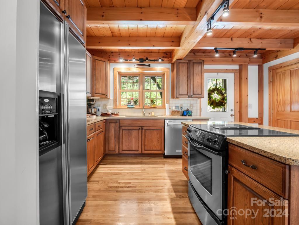 1065 South Cove Road Mill Spring, NC 28756 - Photo 11 of 48 a kitchen with stainless steel appliances granite countertop a sink a stove and refrigerator