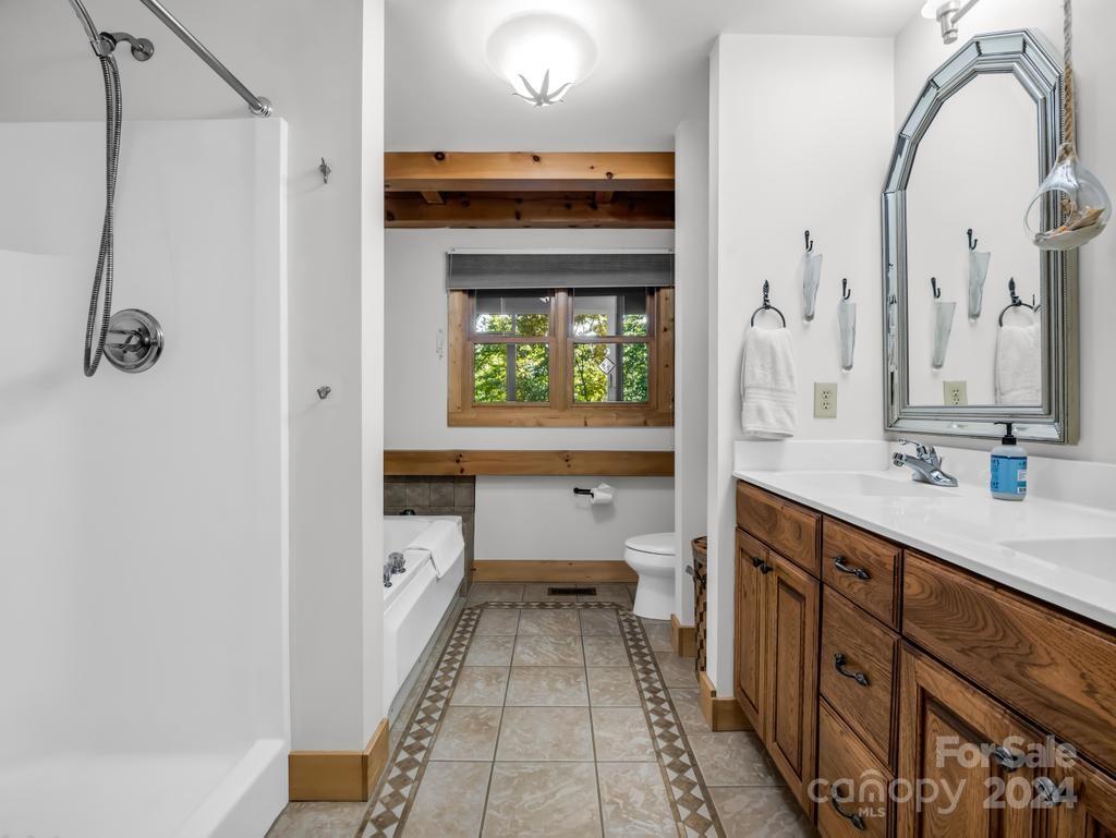 1065 South Cove Road Mill Spring, NC 28756 - Photo 15 of 48 a bathroom with a double vanity sink mirror and toilet