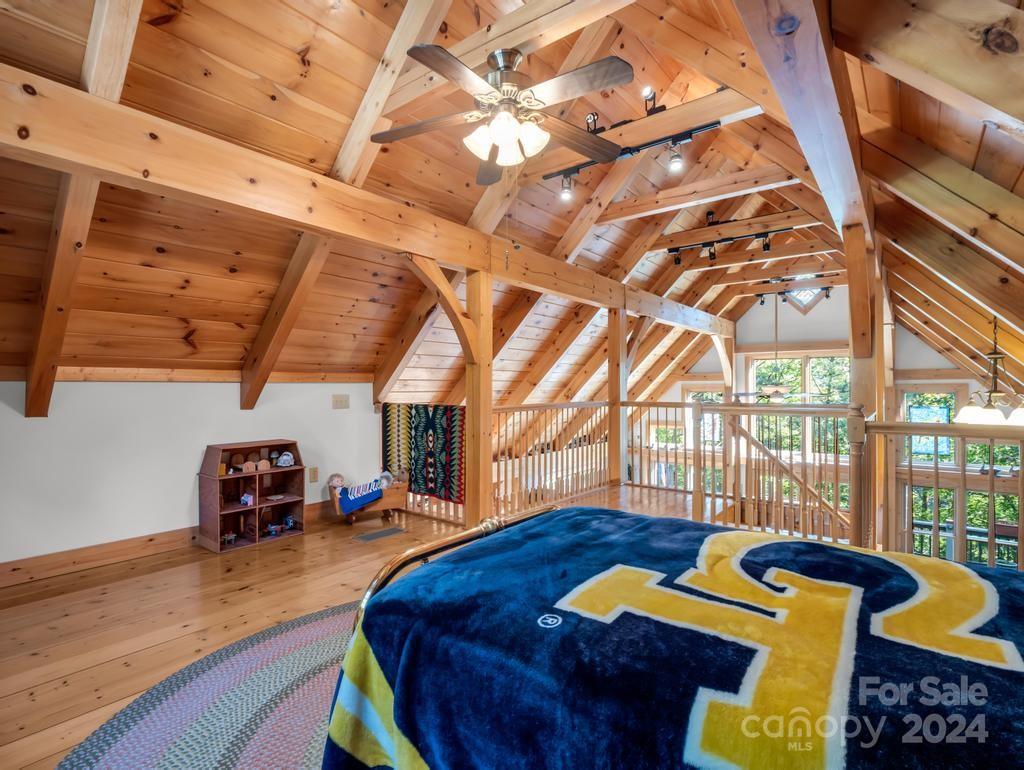 1065 South Cove Road Mill Spring, NC 28756 - Photo 19 of 48 a bedroom with furniture and a wooden floor