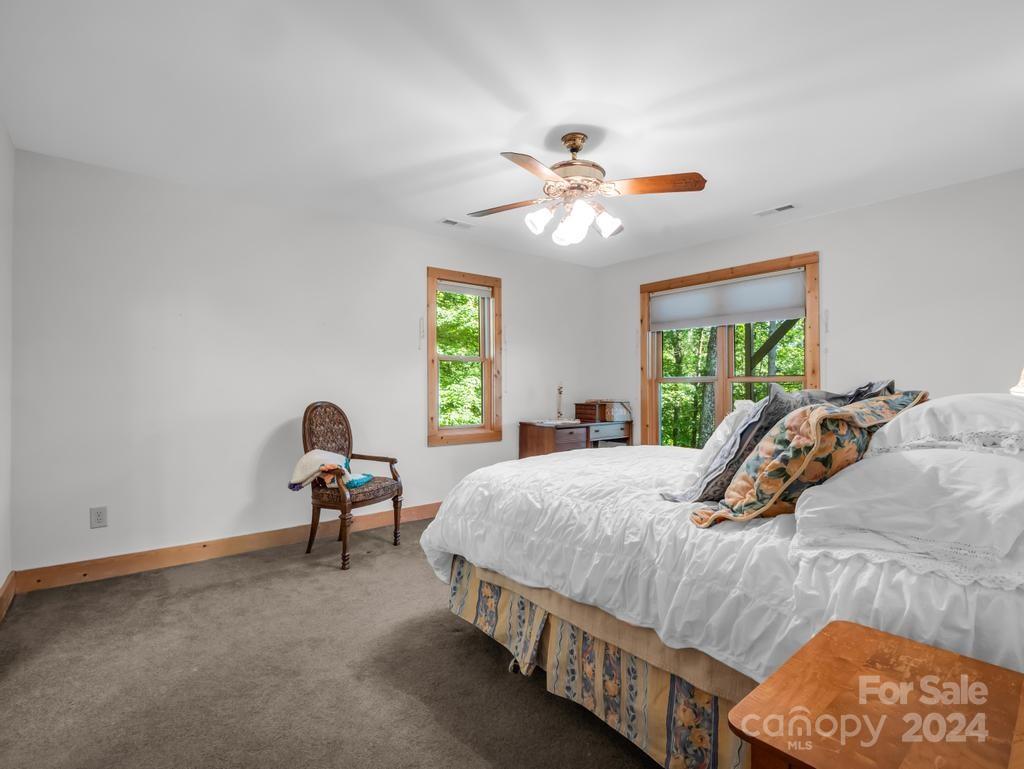 1065 South Cove Road Mill Spring, NC 28756 - Photo 21 of 48 a bedroom with a bed a chandelier and a window