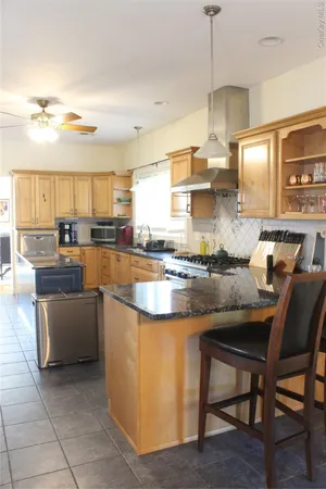 a kitchen with stainless steel appliances granite countertop a stove a sink and a refrigerator