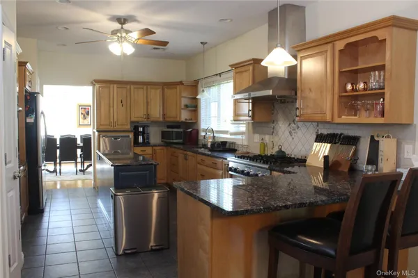 a kitchen with stainless steel appliances granite countertop a sink a stove counter space and dining table