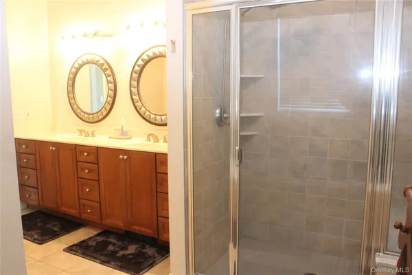 a bathroom with a granite countertop shower a sink and a mirror