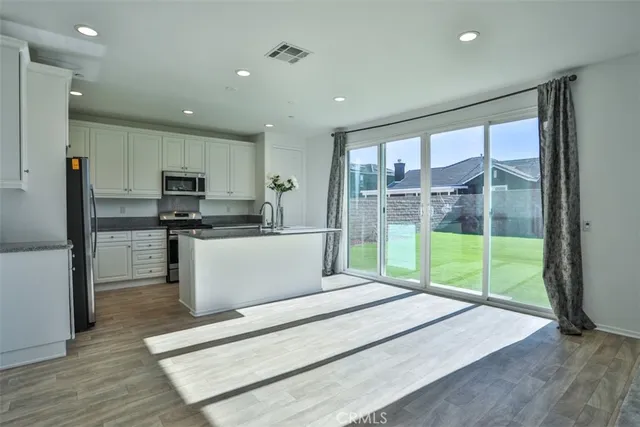 a open kitchen with white cabinets and stainless steel appliances