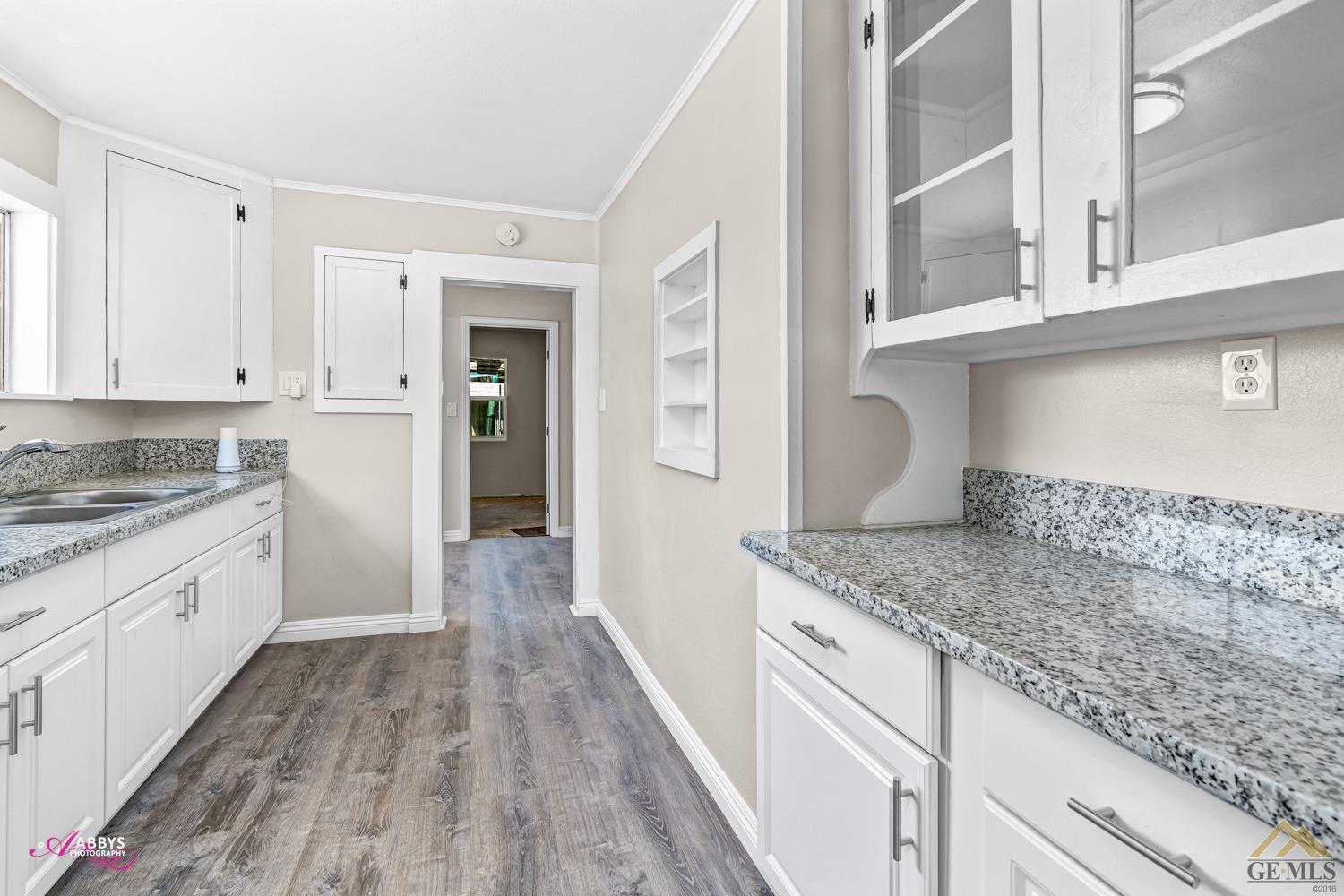 Undisclosed Address Taft, CA 93268 - Photo 19 of 30 a kitchen with granite countertop white cabinets and white appliances