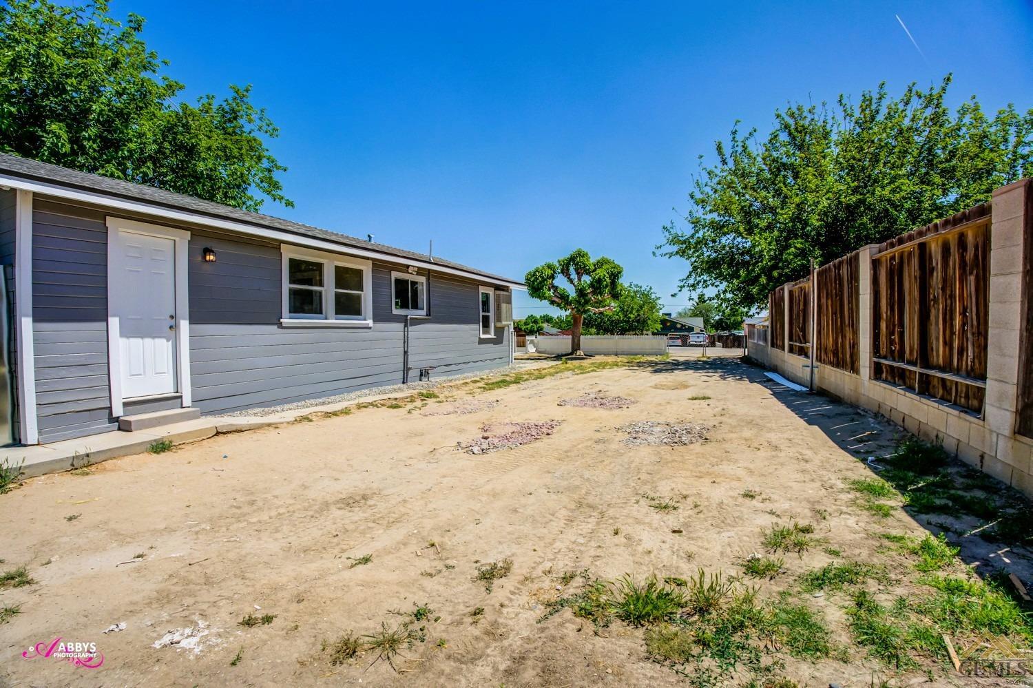 Undisclosed Address Taft, CA 93268 - Photo 28 of 30 a backyard of a house with wooden fence and large trees