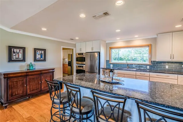 a spacious bathroom with a granite countertop sink and a large mirror