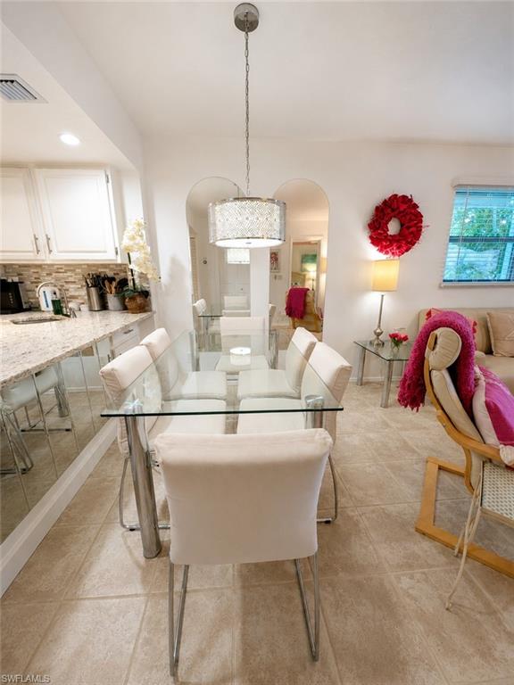 600 Neapolitan Way, Unit 449 Naples, FL 34103 - Photo 9 of 44 Dining area with tile flooring and a drum pendant light fixture