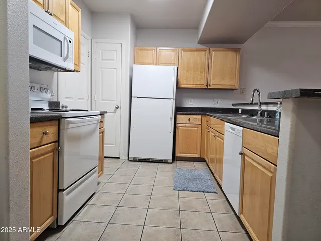 a kitchen with stainless steel appliances granite countertop a refrigerator sink and stove