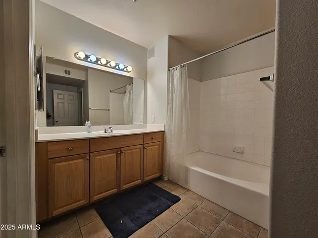 a spacious bathroom with a mirror a bathtub and a sink