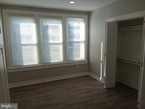an entryway in a hall with a window and wooden floor