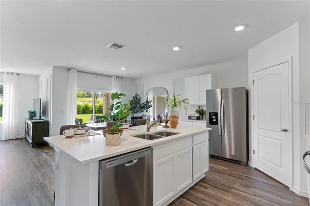 a kitchen with a sink refrigerator and cabinets