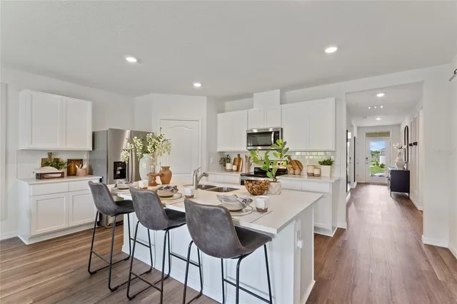a view of a dining room and livingroom with furniture wooden floor a chandelier