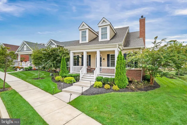 a front view of a house with a yard and potted plants