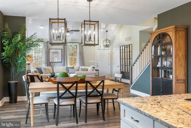 a dining room with furniture a chandelier and wooden floor