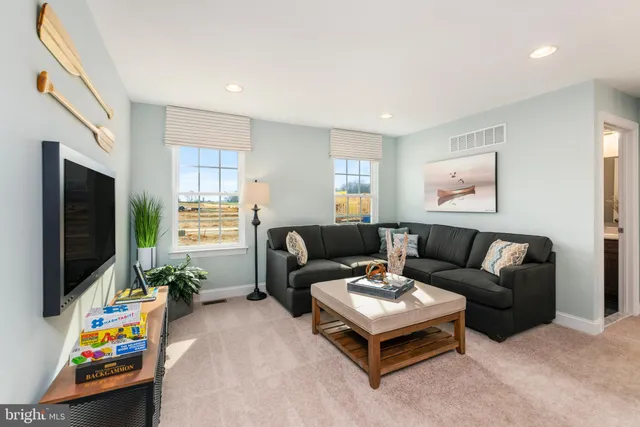 a living room with furniture a flat screen tv and a window