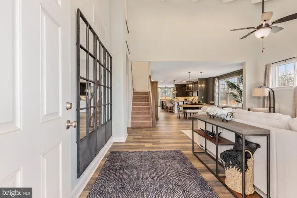 a view of a hallway with wooden floor and a kitchen view