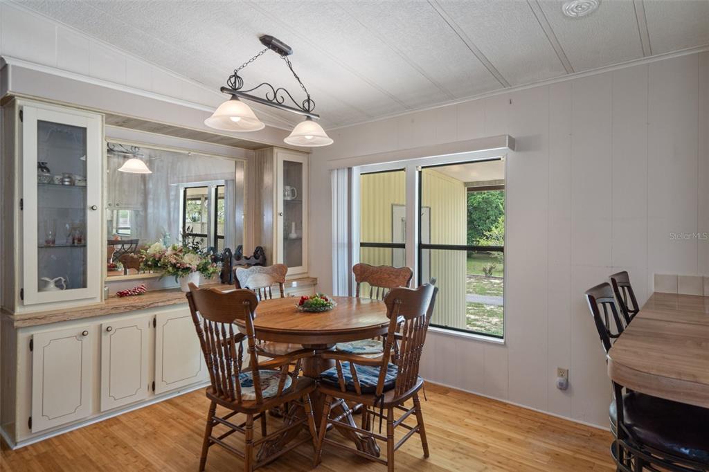 12306 Club House Road Brooksville, FL 34613 - Photo 17 of 36 a view of a dining room with furniture window and wooden floor