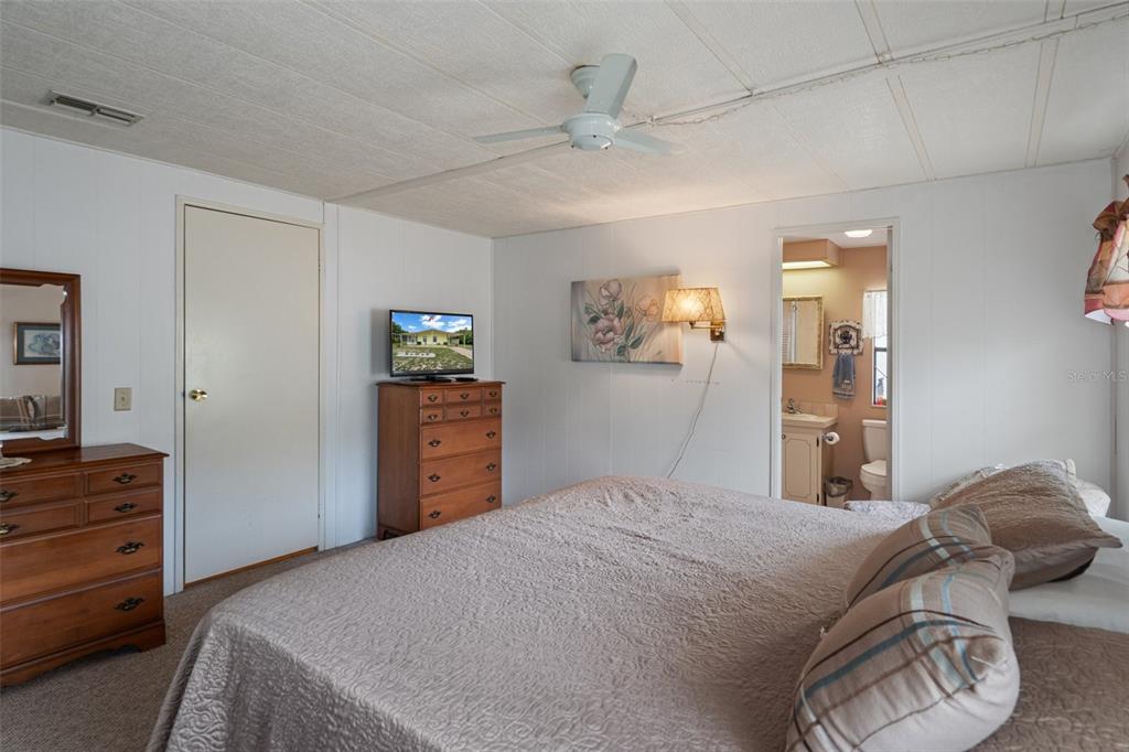 12306 Club House Road Brooksville, FL 34613 - Photo 23 of 36 a bedroom with a bed and a dresser