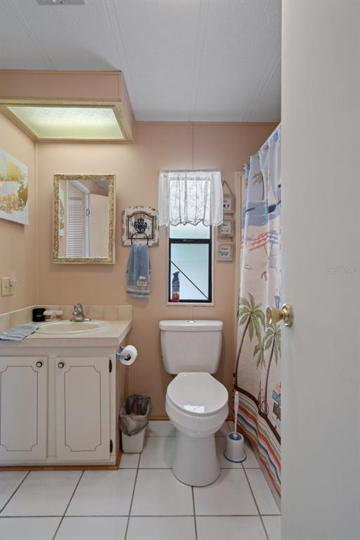 12306 Club House Road Brooksville, FL 34613 - Photo 25 of 36 a bathroom with a toilet a sink and mirror